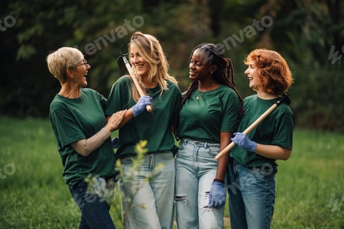 Preview: Happy volunteers taking a break while working together in the park