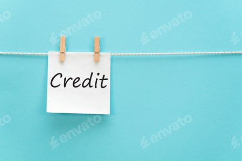 Preview: sticker with the inscription Credit hangs with a clothespin on a rope on a blue background