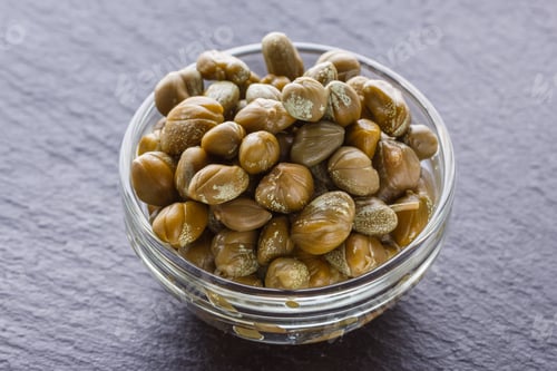 Preview: pickled capers on a dark stone background