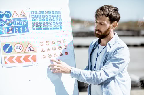 Preview: Man Explaining Traffic Signs on Whiteboard Outdoors