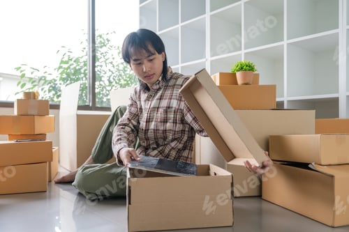 Preview: Asian male pack thing in box to move house. The idea of moving house