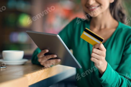 Preview: Unrecognizable young lady banking online, using digital tablet at cafe