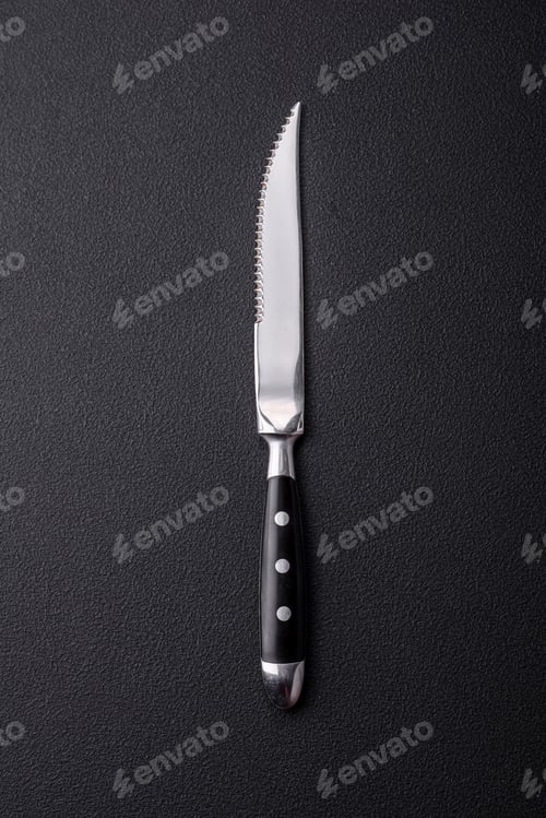 Preview: Metal kitchen knife on a dark textured concrete background