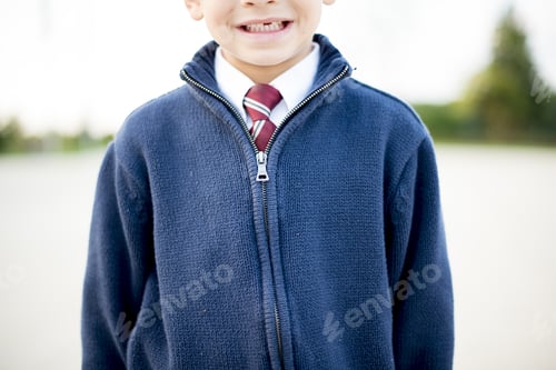Preview: Closeup shot of a boy smiling in a white shirt with a tie under a blue jacket
