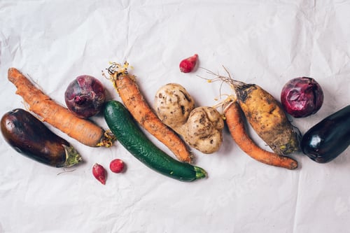 Preview: Ugly organic rotten vegetables with mutations on craft paper background. Concept of zero waste