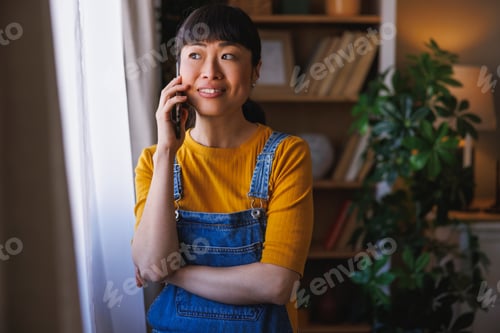 Preview: Woman having a phone conversation while relaxing at home
