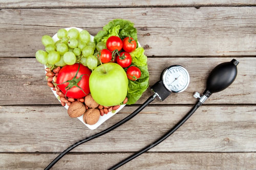 Preview: top view of fresh various vegetables, fruits and blood pressure gauge on wooden surface, healthy