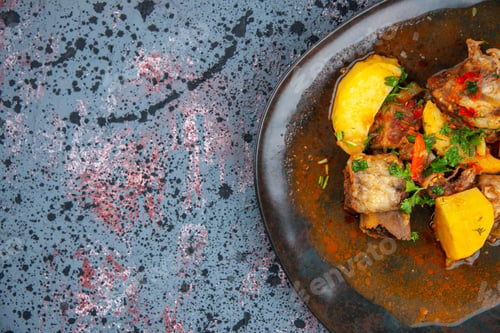 Preview: Half shot of delicious dinner with meat potatoes served with green on the right side on mix colors