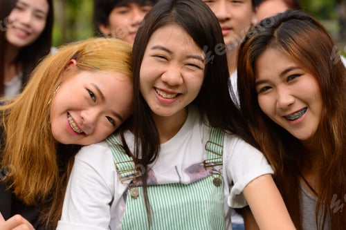 Preview: Happy young group of friends having fun together at the park