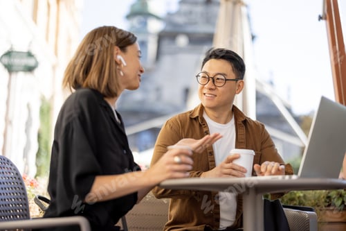 Preview: People talking and working with laptop in cafe