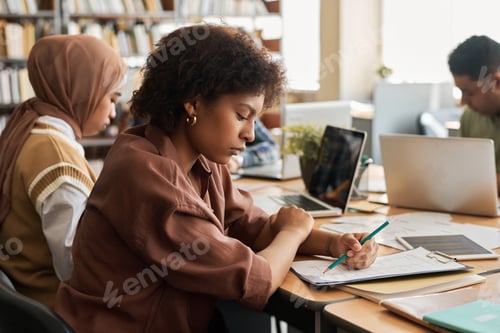 Preview: Young woman writing test in class