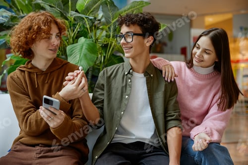 Preview: Teenagers listening music via mobile phone during pastime in shopping mall
