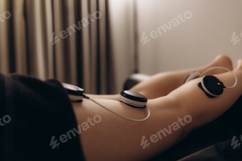 Preview: Physiotherapist applying electro stimulation in physical therapy to a young woman.