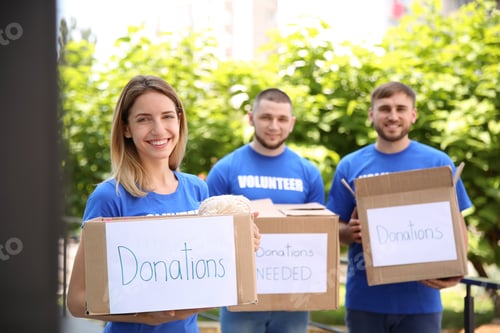Preview: Young volunteers holding boxes with donations for poor people outdoors