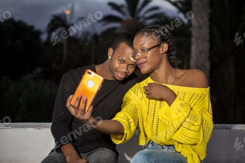 Preview: Young ethnic couple taking selfie outdoors