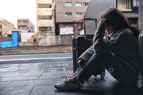 Preview: A woman sitting with feeling sad while traveling with a lot of baggages