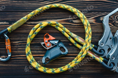 Preview: Isolated photo of climbing equipment. Parts of carabiners lying on the wooden table