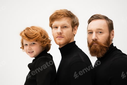 Preview: red haired men and smiling boy in black turtlenecks looking at camera isolated on grey