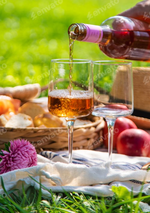 Preview: Wine in hands of woman at picnic. Selective focus.