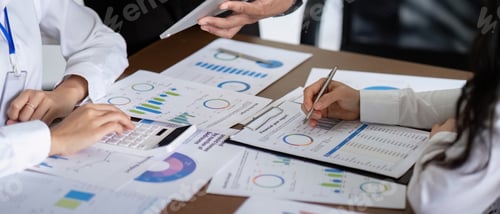 Preview: Business Team Discussing Analysis and Planning in a Meeting with Charts and Graphs on the Table