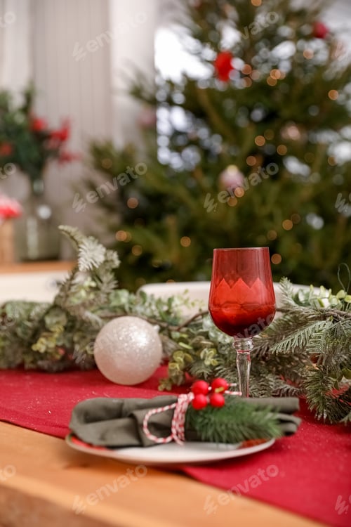 Preview: Christmas traditional colors decorated table with Christmas tree, red glass