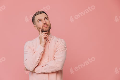Preview: Cute unshaven man in pink shirt thinking about something and posing isolated on pink background