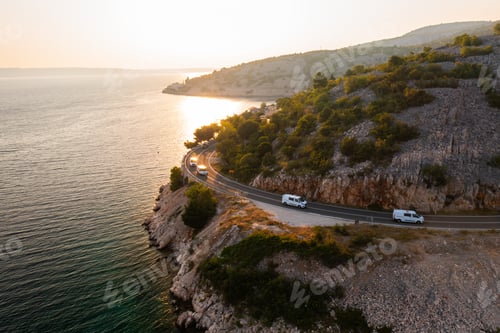 Preview: Scenic coastal road travels along the waterfront at sunset in a beautiful mountainous region