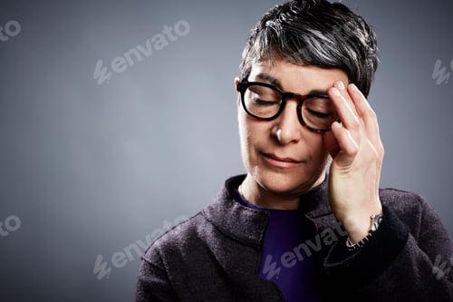 Preview: Studio portrait of mature businesswoman with eyes closed and hand on forehead