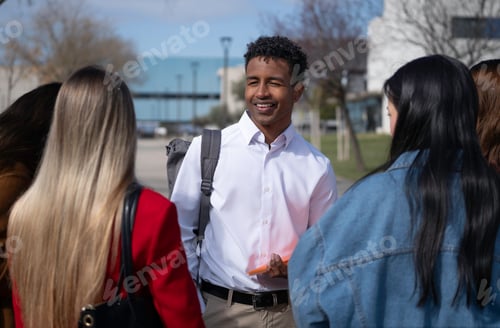 Preview: Smiling university african american student talking with friends outdoors on campus