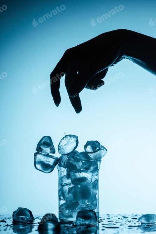 Preview: cropped view of person throwing ice cubes into glass