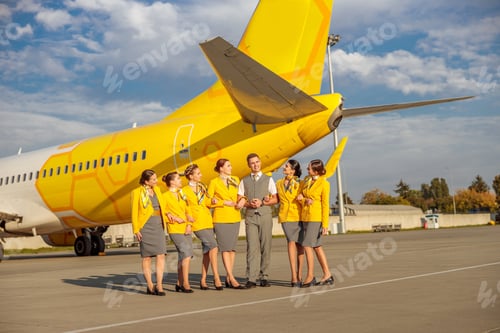 Preview: Airline workers standing near yellow aircraft at airfield
