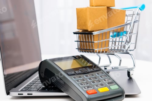 Preview: POS on the laptop and shopping cart with cardboard boxes on the background