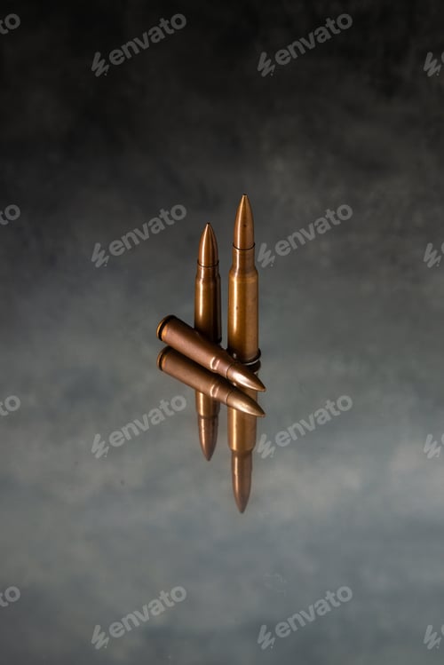 Preview: front view of brown bullets on gray desk gun tank death war shooting