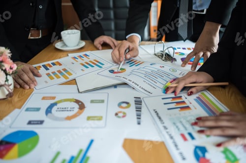 Preview: Close up of business people working with business document during discussion at meeting.