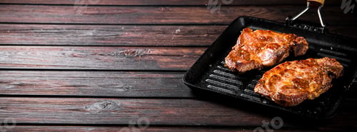 Preview: Grilled pork steak in a frying pan.