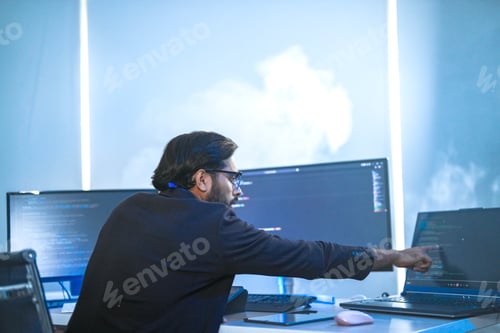 Preview: focused Indian financial analyst or software developer working late in a modern office