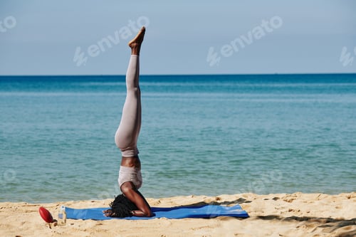 Preview: Woman doing headstand on beach