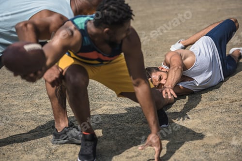 Preview: group of young multicultural men playing football on court
