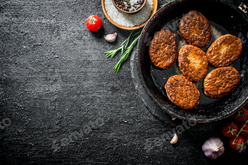 Preview: Cutlets in pan with rosemary, garlic and tomatoes.