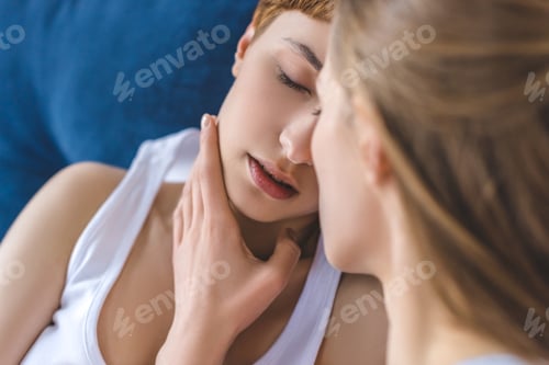 Preview: close-up shot of young kissing lesbian couple in bed