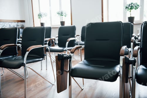 Preview: Business classroom at daytime with many of black chairs. Ready for students