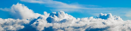 Preview: Fluffy clouds on a clear blue sky. Banner format. Background for design.