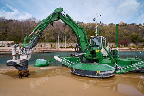 Preview: Green amphibious dredging machine working at the edge of a beach and water channel