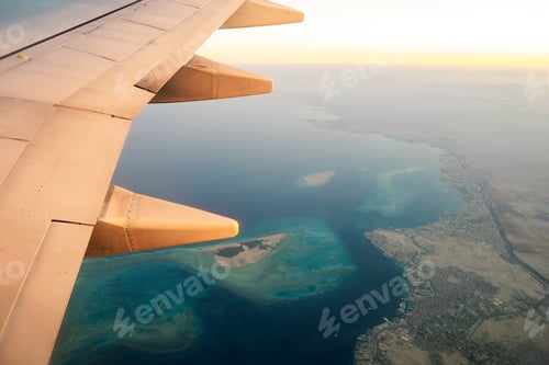 Preview: View from airplane on the aircraft white wing flying over ocean landscape in sunny morning. Air