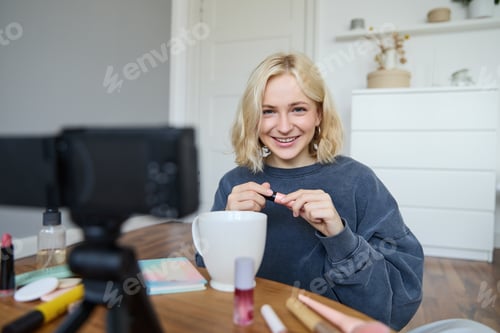 Preview: Portrait of blond smiling woman records a lifestyle blog, vlogger or makeup artist recording video