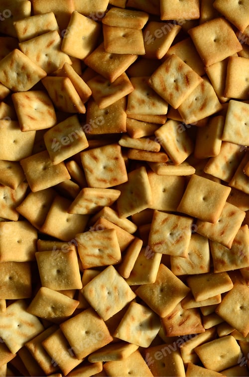 Preview: A lot of small cookies are square shaped. A pattern of a yellow salt cracker. Background