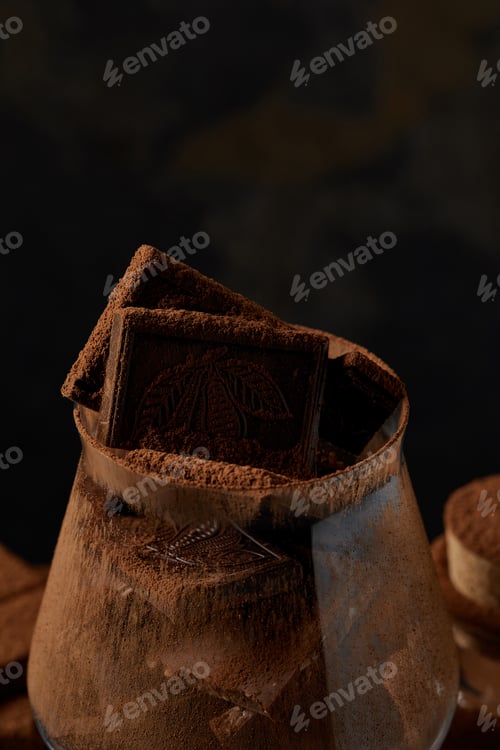 Preview: close-up view of glass with delicious chocolate pieces and cocoa powder