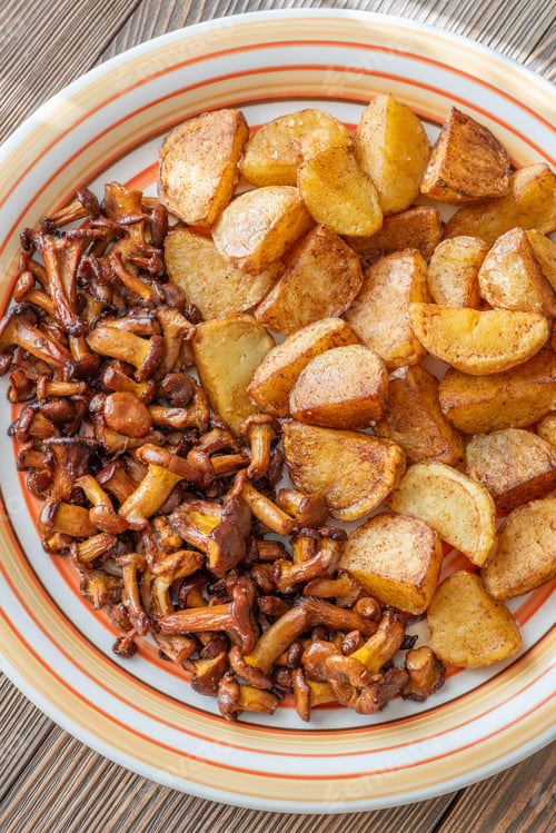 Preview: Fried potatoes chanterelle mushrooms seasoned paprika rustic wooden table plate