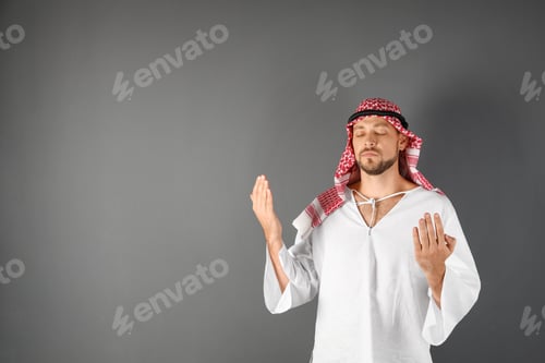 Preview: Muslim man praying on gray background. Space for text