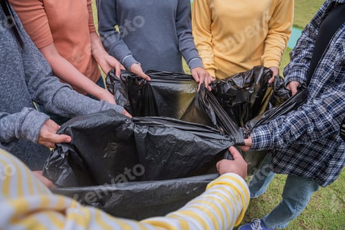 Preview: Volunteers prepare black plastic bags to collect rubbish in the park